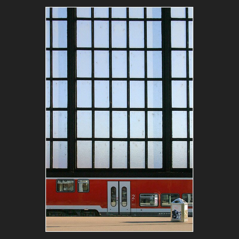 Ein etwas anderes Bahnsteigbild: Unter der gl�sernen Seitenwand der Bahnsteighalle hindurch blickt man auf einen Doppelstockwagen. Bei der Aufnahme habe ich auf Symmetrie geachtet, so beim dem  Gitter , aber auch die Waggont�re befindet sich in Bildmitte. Aufgenommen wurde das Bild beim Umsteigen im Karlruher Hauptbahnhof.