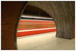 U-Bahnhof  Schweinau  in N�rnberg: Durchrauschender roter U-Bahnzug, gesehen durch zwei gegenl�ufige B�gen.
