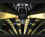 Eine Metrostation in Kopenhagen, von Jonas anders fotografiert. Im Vordergund die unter den Rolltreppenhandl�ufen angebrachte Beleuchtung, mehrfach gespiegelt in den Glasfl�chen. 